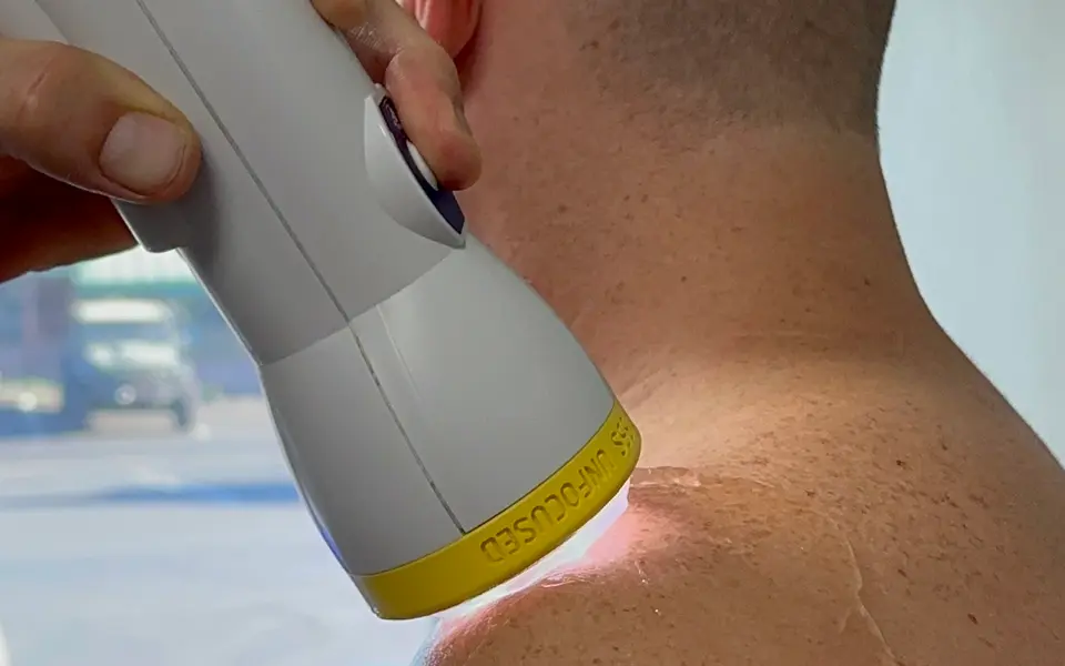 SoftWave applicator treating the back of a patient's neck